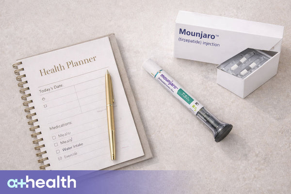 Clean medical flat lay with health planner, pen, and medication packaging featuring mounjaro, no people, neutral background